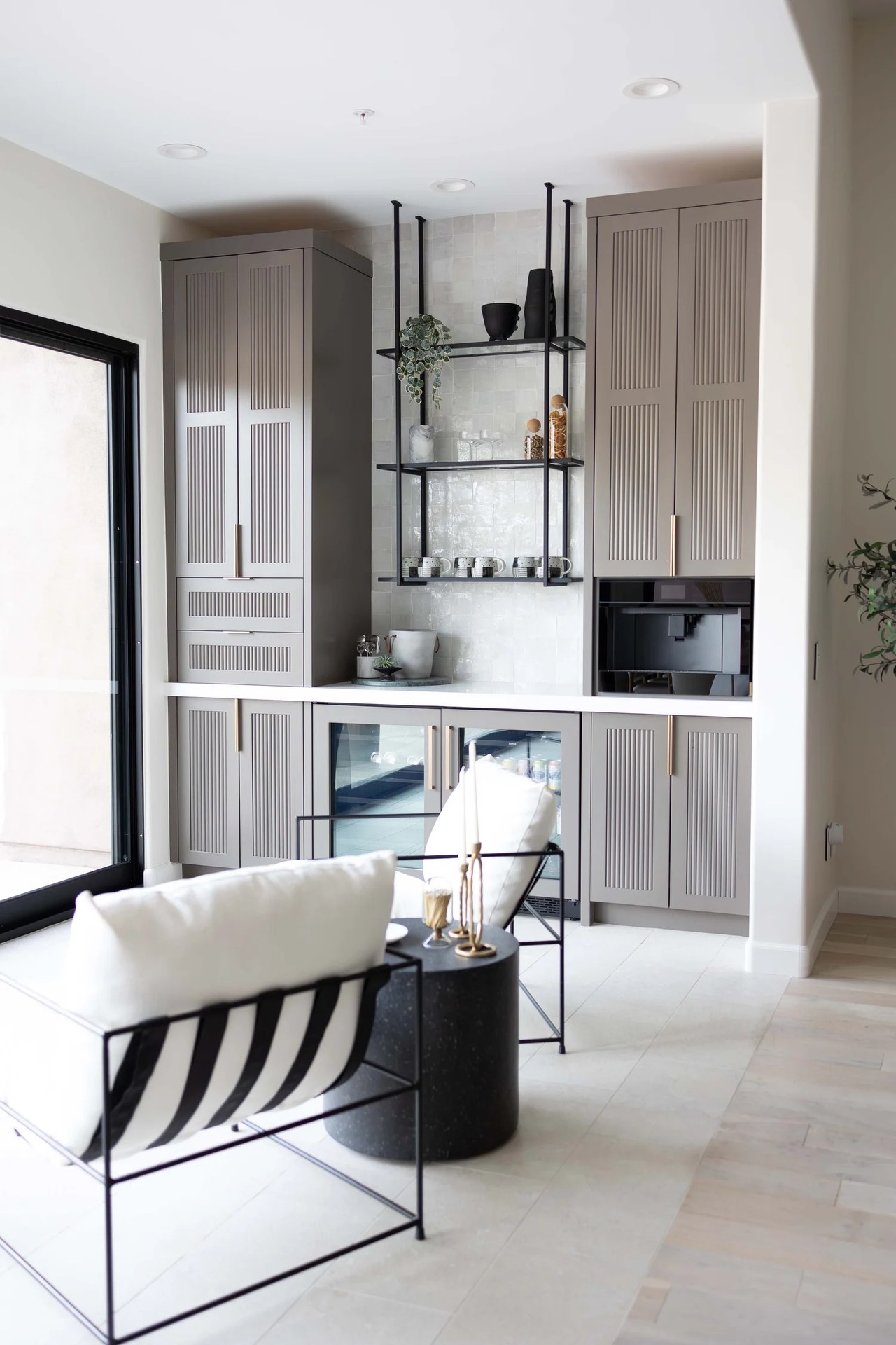 A taupe millwork bar with fluted doors, open steel shelves, and a built-in coffee machine. Devotion, Ancala, Desert Dwelling.