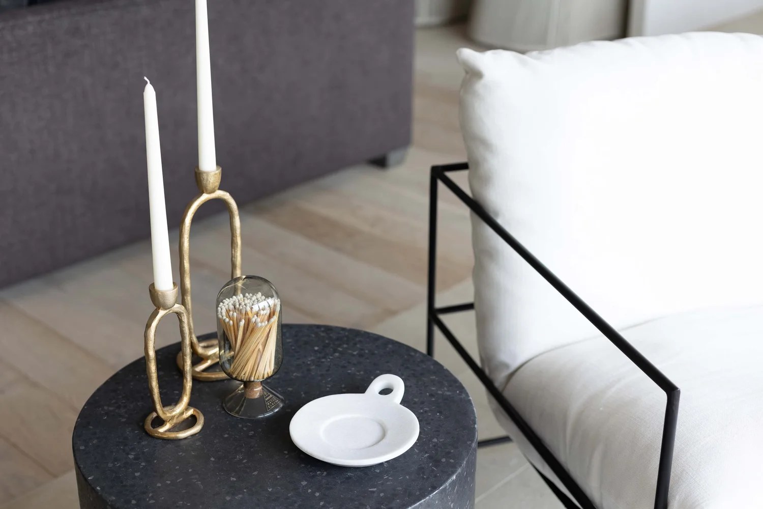 A dark stone side table with brass candlesticks and a glass of matches. Devotion, Ancala, Desert Dwelling.