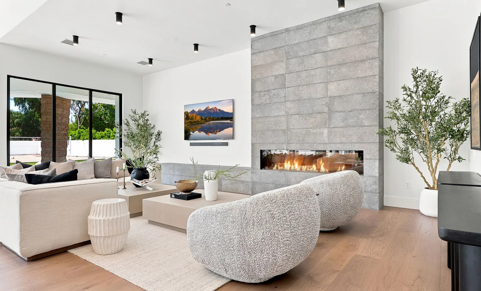 A concrete fireplace wall, bouclé chairs, and a quiet sitting room of oak and linen. I, Run, Paradise Valley, Desert Dwelling.
