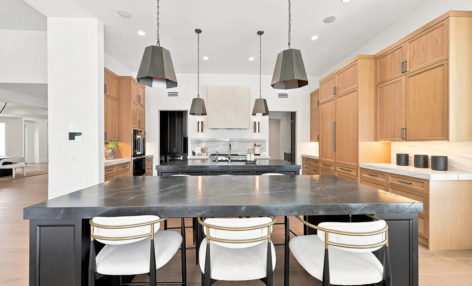 The working kitchen from the seating island — oak, black marble, and a plaster hood. I, Run, Paradise Valley, Desert Dwelling.