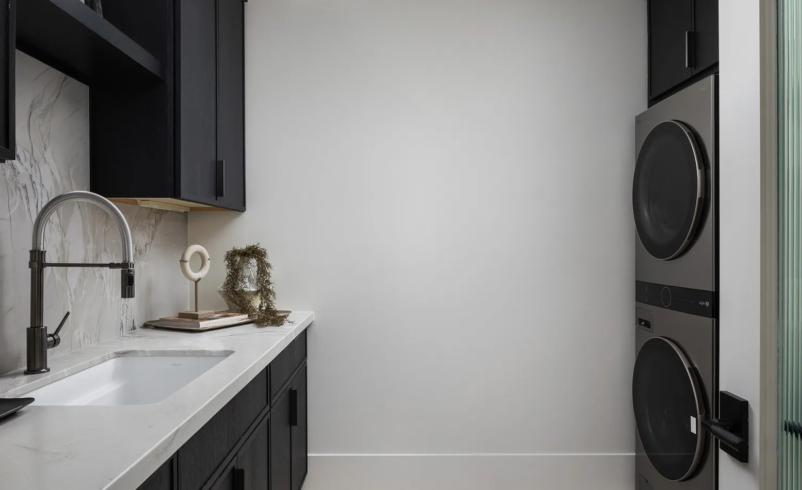 The laundry — black millwork, a marble sink, and stacked machines. I, Run, Paradise Valley, Desert Dwelling.