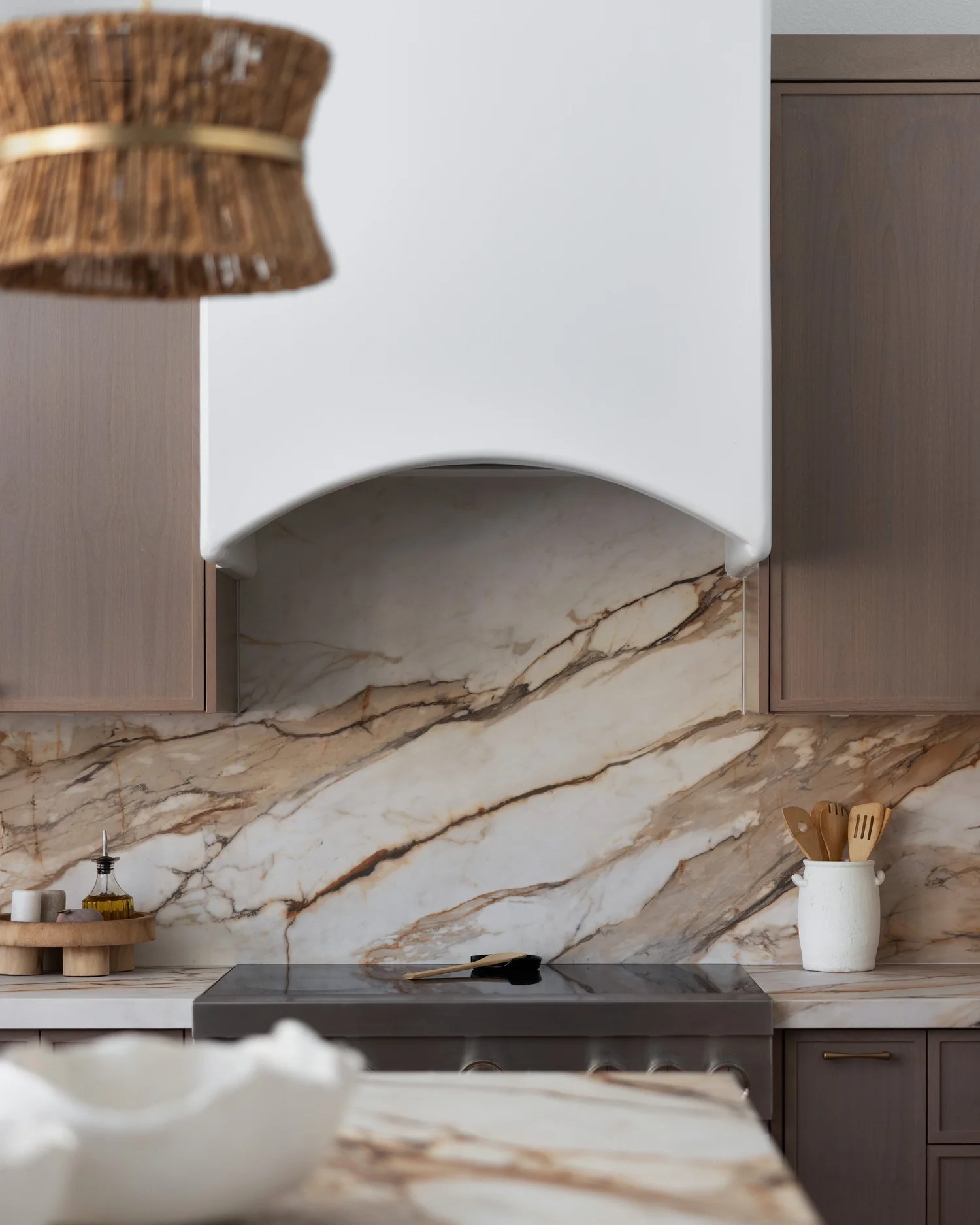 The plaster hood against veined marble, with a woven pendant in the foreground. New Beginnings, Scottsdale, Desert Dwelling.