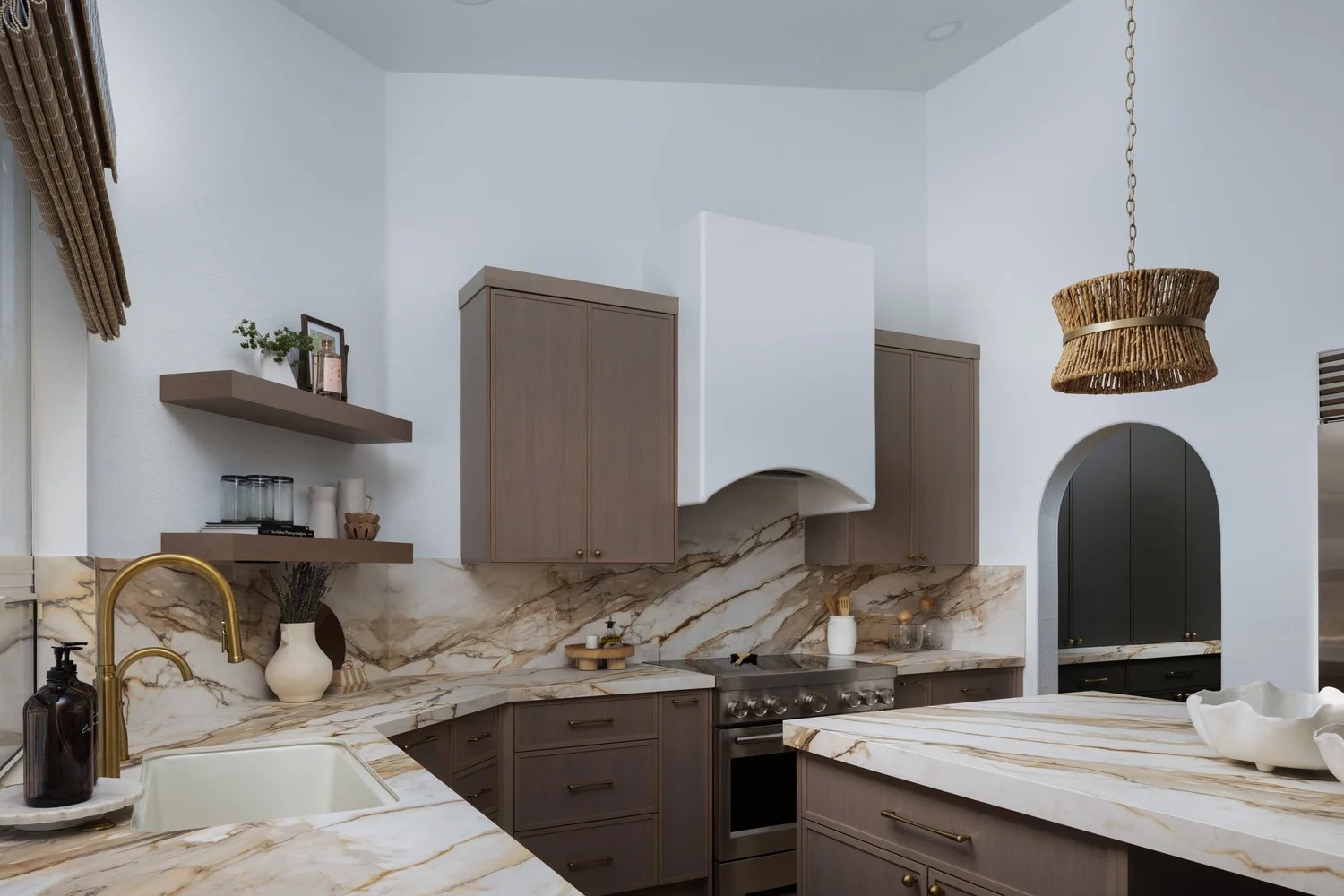 The working kitchen — brass faucet, farmhouse sink, and the range beyond. New Beginnings, Scottsdale, Desert Dwelling.