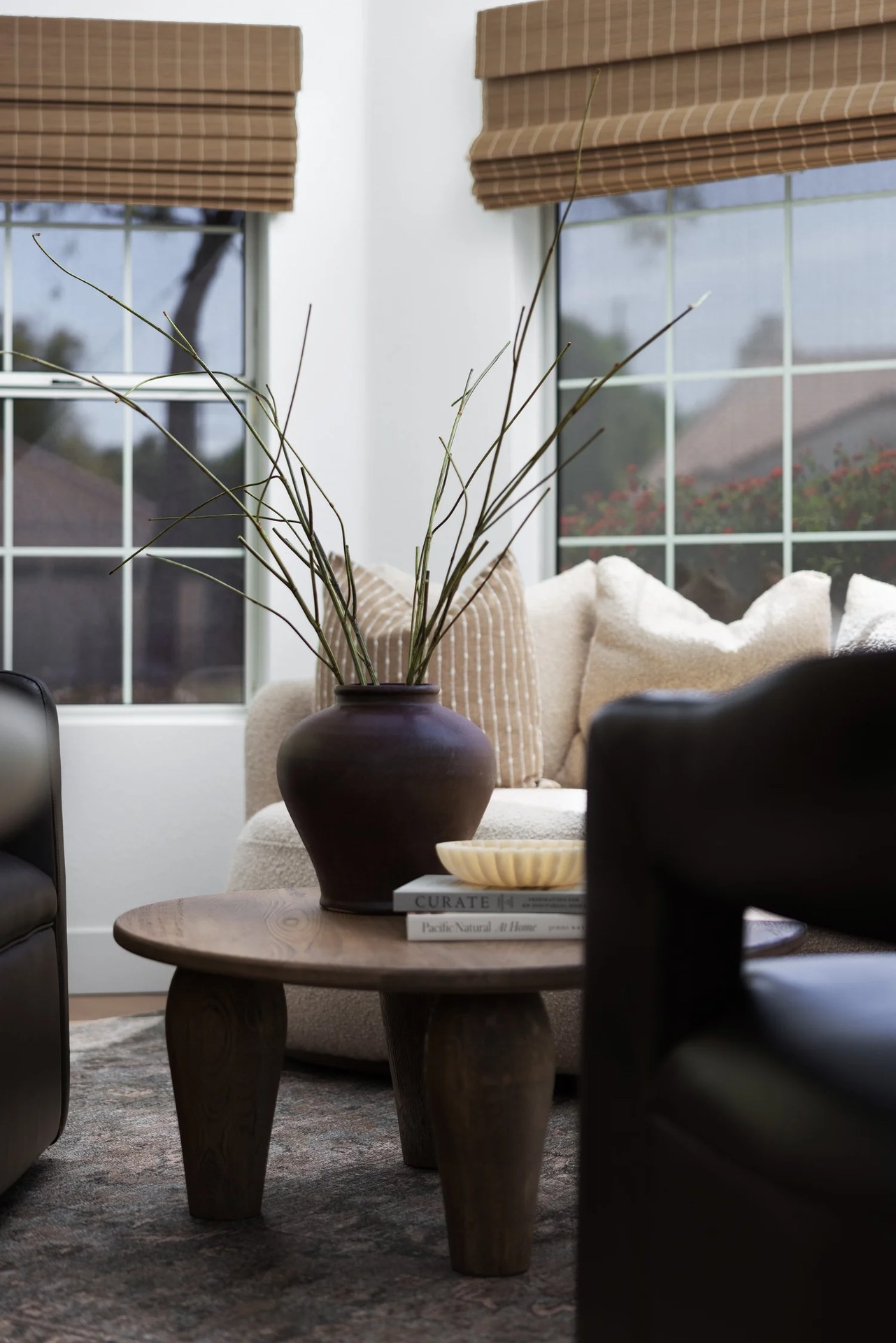 A living corner — bouclé sofa, a dark vessel of branches, and a sculpted oak table. New Beginnings, Scottsdale, Desert Dwelling.