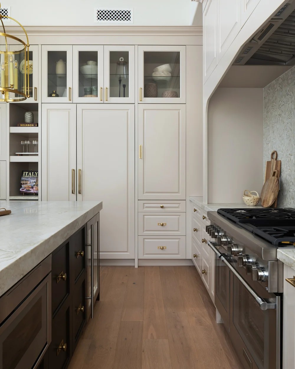 The range wall — cream cabinets, a mosaic hood niche, and a stainless range. Tuckey, Scottsdale, Desert Dwelling.