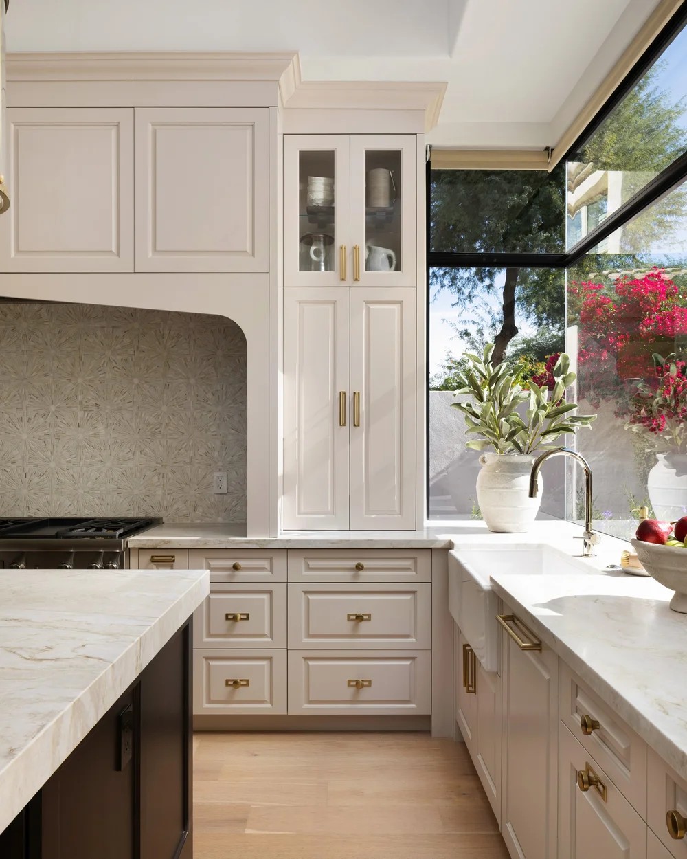 Cream millwork, a farmhouse sink, and a corner window to the garden. Tuckey, Scottsdale, Desert Dwelling.