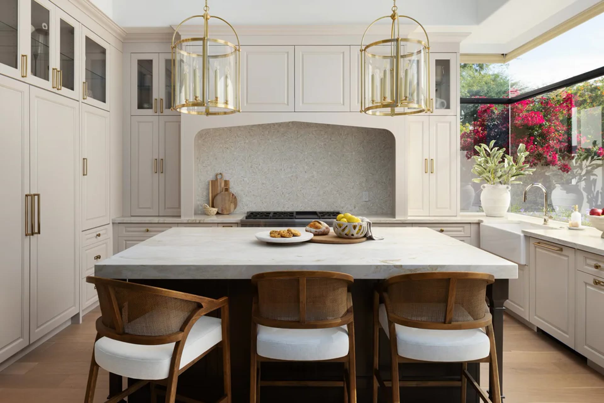 Cream millwork kitchen with brass lanterns and cane-backed stools. Tuckey, Scottsdale, Desert Dwelling.