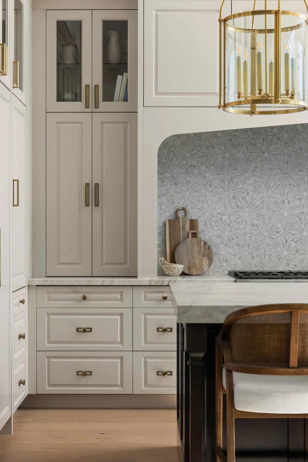 Glass-front millwork, brass hardware, and a starburst mosaic backsplash. Tuckey, Scottsdale, Desert Dwelling.