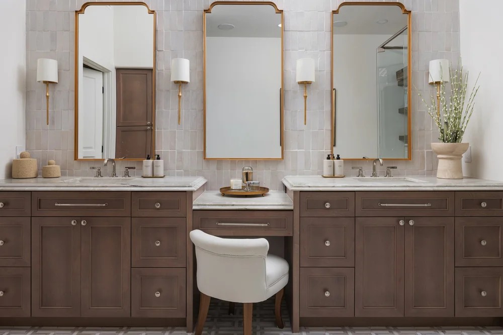The primary bath vanity — three gilt mirrors, taupe millwork, and a makeup desk. Tuckey, Scottsdale, Desert Dwelling.